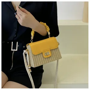Stylish straw box shoulder bag with yellow flap and top handle for vacation beach travel use.