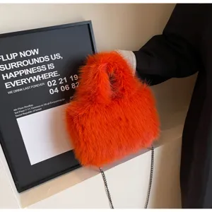 Borsa a mano in peluche arancione vivace con tracolla a catena e morbida consistenza soffice.