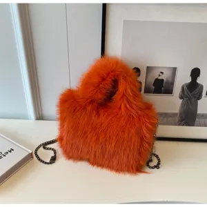 Primo piano della borsa a tracolla in peluche arancione soffice con catena di metallo nero.