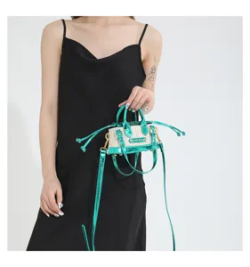 Mini straw shoulder bag with metallic green PU leather patchwork and top handles design.