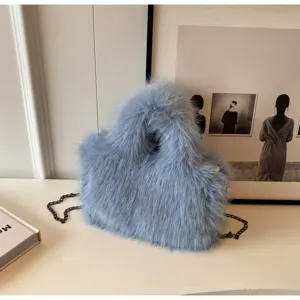 Dettaglio borsa a tracolla in pelliccia sintetica soffice blu con cinturino a catena chic.