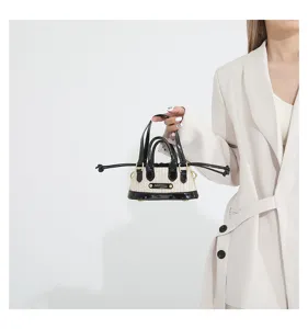 Chic woven straw mini handbag with patent leather trim and top handles for women summer fashion.