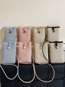 Woven straw crossbody phone bag for women, cute small shoulder bag with cute button decor.