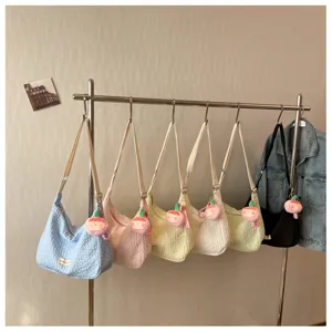 Detailed view of trendy crinkled bubble shoulder bags hanging on rack in multiple pastel colors.