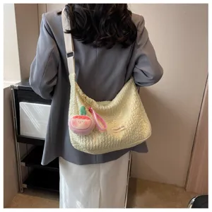 Creamy yellow pleated bubble shoulder bag for women, chic hobo tote with cute plush charm.