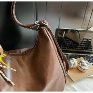 Détail de sac à bandoulière marron rétro en cuir PU, cabas fourre-tout chic et décontracté.