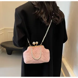 Vue de détail d'un sac bandoulière en peluche rose chic avec élégante chaîne en perles.
