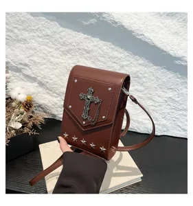 Detailed shot of the retro brown crossbody mini bag featuring gothic cross and star studs.