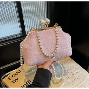 Chic sac bandoulière peluche rose élégant avec poignée perle pour tendance mode d'hiver.