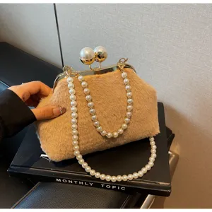 Détail du sac coquillage en peluche duveteuse avec poignée en perles élégante et fermoir métal.