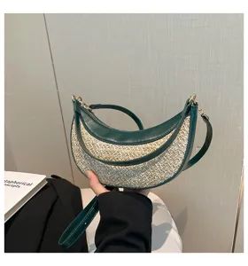 Detailed shot of the stylish crescent straw shoulder bag with green leather trim and strap.