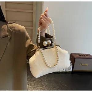 Vue détaillée du sac à main en fausse fourrure blanche avec poignée perle et fermoir métal.