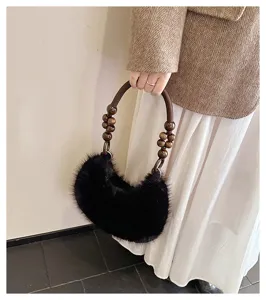 Detail view of a black plush handbag featuring unique wooden bead handle and soft furry texture.