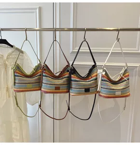 Trendy color-blocked woven shoulder bag for women, casual striped bucket bag for spring.