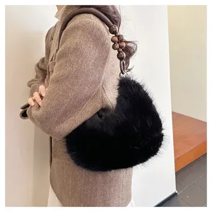 Details of stylish plush handbag featuring wooden bead handle and soft fluffy texture design.