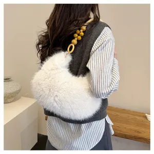 Soft plush shoulder bag detail showing fluffy white fabric and unique wooden bead handle.