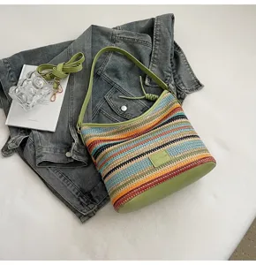Colorful woven bucket bag with green PU accents and casual striped design details.