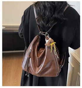 Vue détaillée du sac à dos bandoulière en cuir PU marron vintage avec charmant ours et pompon.