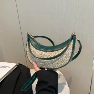 Stylish crescent straw shoulder bag for women, trendy dark green trim, ideal for beach.