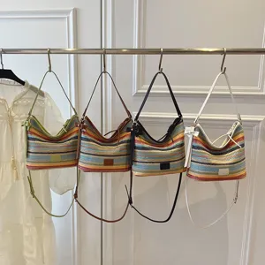 Trendy color-blocking woven shoulder bucket bag featuring multi-color stripes and cute bow.