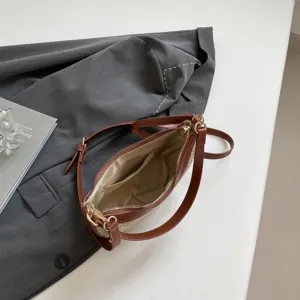 Woven straw underarm shoulder bag for women, stylish crescent design with brown leather trim.