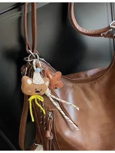 Sac à dos bandoulière en cuir marron rétro avec joli pendentif ours pour femmes.