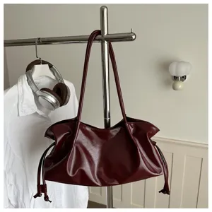 Bordeauxrode slouchy schoudertas voor dames, stijlvolle kunstlederen tas met trekkoord.