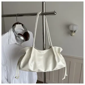 Gedetailleerd overzicht van een minimalistische witte slouchy schoudertas met trekkoord.