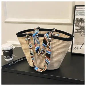 Woven straw tote bag with colorful silk scarf handle and wooden bead pendants for summer beach.
