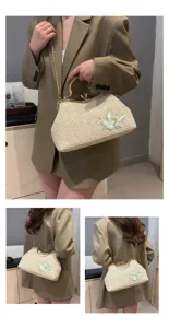 Detailed view of women straw woven handbag with floral embroidery and chain strap.