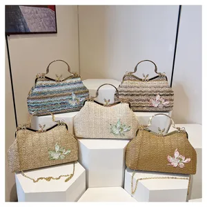 Stylish woven straw shoulder bag with floral embroidery and metal handle for women fashion.