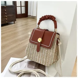 Woven straw crossbody bag with brown leather flap and top handle, chic summer shoulder handbag.