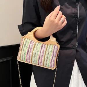 Elegante bolso bandolera de paja para mujer con asa de madera y patrón colorido.