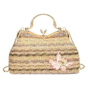 Stylish woven straw handbag with gold metal frame and embroidered flower detail for women.