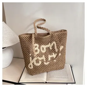 Woven straw tote bag for women, stylish beach shoulder bag with chic letter embroidery.
