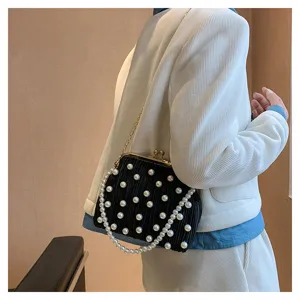 Sac a main plisse noir avec decoration de perles et chaine pour soiree de femmes elegantes.