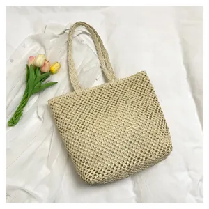 Close-up detail of the woven straw shoulder bag, showing hollow texture and delicate handle.