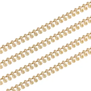 Detalle de cadena de acero inoxidable chapada en oro con dijes para bisutería DIY.
