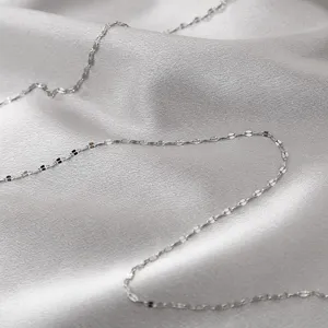 Detailed view of stainless steel flat chain necklace component, delicate texture and shiny finish.