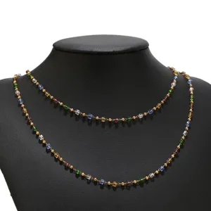 Detailed view of a multi-color glass bead and gold chain necklace, elegant jewelry design.