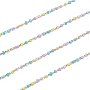Close-up detail of colorful beaded chain, pastel small round beads on fine metallic link strand.