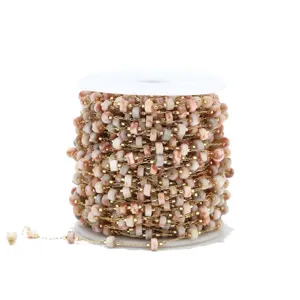 Close-up of beaded chain spool, gold-colored metal links with natural stone beads for DIY crafts