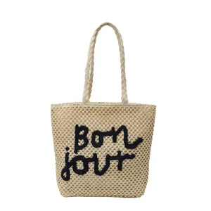 Stylish straw woven shoulder bag for women with embroidered letter design, beach holiday.