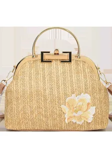 Sac à main tissé en paille vintage avec poignée en métal et broderie florale élégante.
