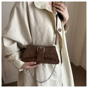 Detailed view of trendy brown leopard print shoulder bag with metallic buckle and chain.