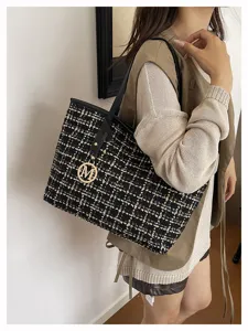 Detailed view of the stylish plaid tote bag showcasing tweed fabric and golden M hardware charm.