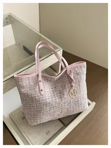 Pink tweed tote bag with leather handles and metal charm for daily stylish wear.