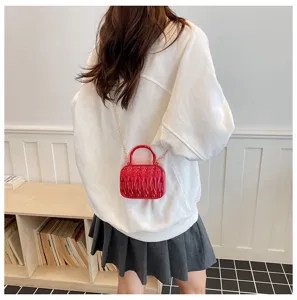 Stylish mini pleated shoulder bag with top handle and elegant gold chain strap in red.