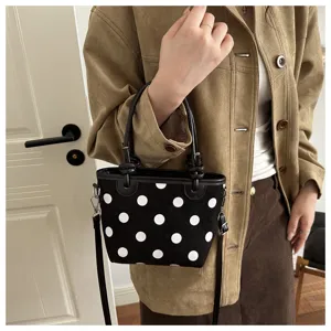 Vista dettagliata della chic borsa a secchiello nera a pois, con motivo elegante e tracolla.