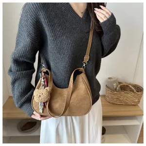 Vista dettagliata della borsa a spalla marrone elegante con ciondolo orsetto per autunno.
